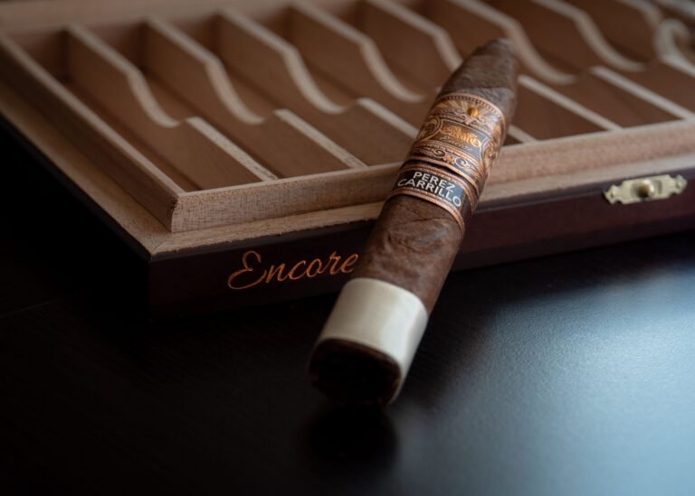 Premium handmade cigar resting on a dark wooden humidor box